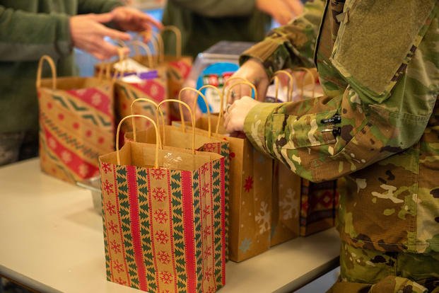 Service members assemble holiday treat bags.