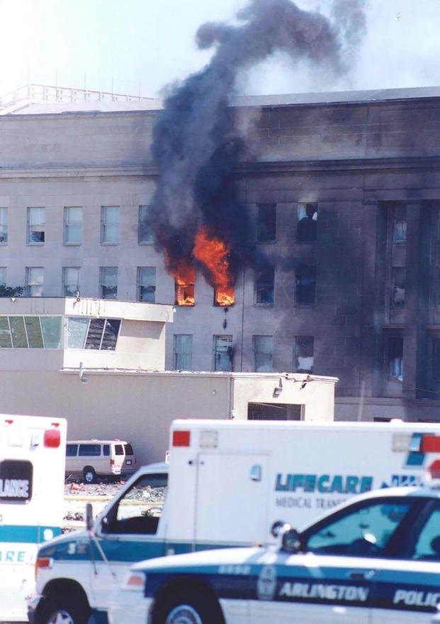 Flames escape from E Ring office windows near the heliport control tower, 11 September 2001.