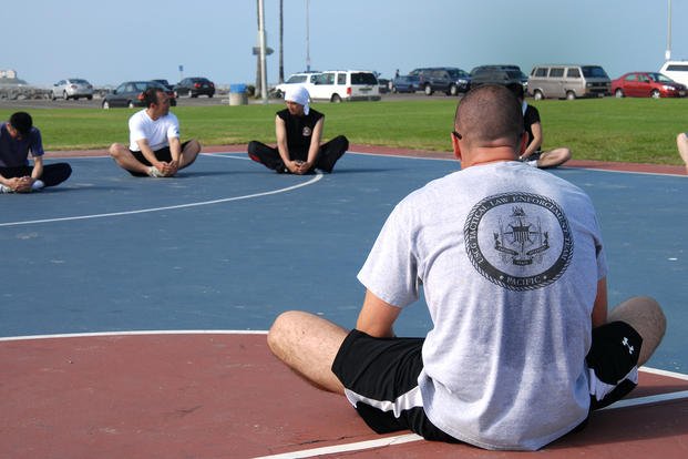 Petty officer 2nd class leads a stretching class.