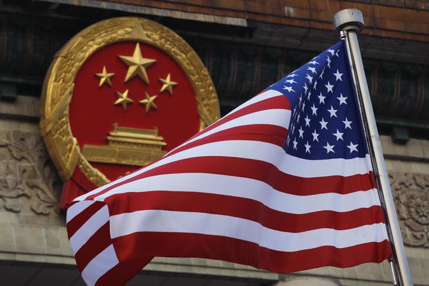 American flag is flown next to the Chinese national emblem