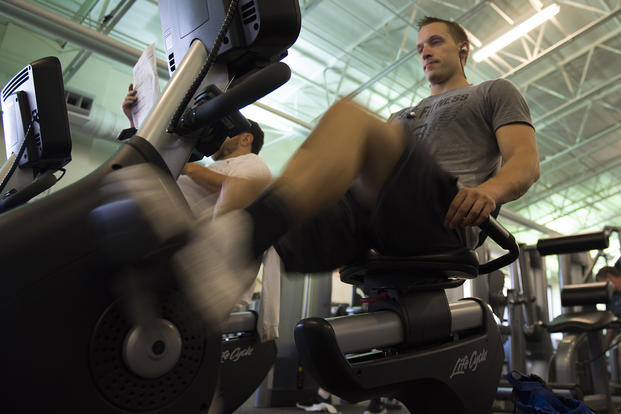 An airman works out on an exercise bike.