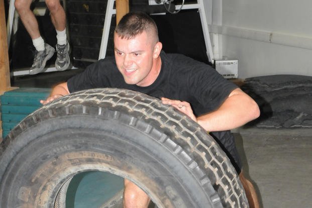 A specialist gets tactically fit by flipping a tire.