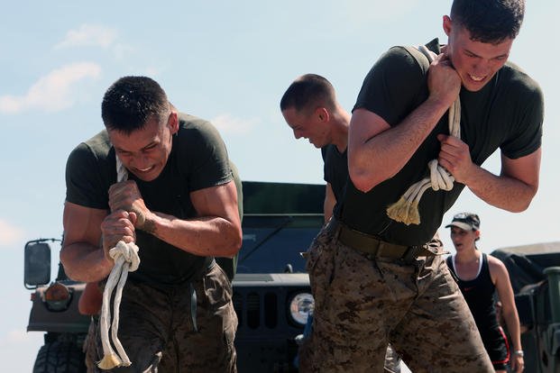 Marines work together to pull a Humvee.