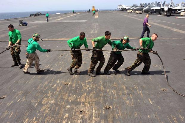 Sailors aboard the USS Enterprise reweave the three wire on the flight deck