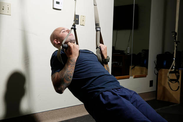 A Marine firefighter trains with the TRX system.