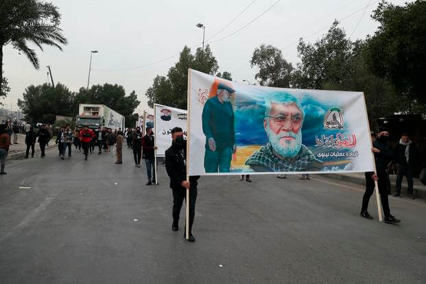 Popular Mobilization Forces members hold posters in Baghdad, Iraq.