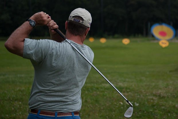 A golfer follows the trajectory of his golf ball at Ramstein Air Base, Germany.