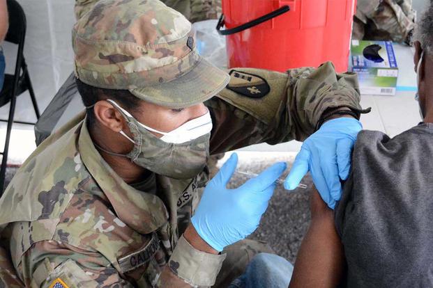A Louisiana National Guardsman administers a COVID-19 vaccine