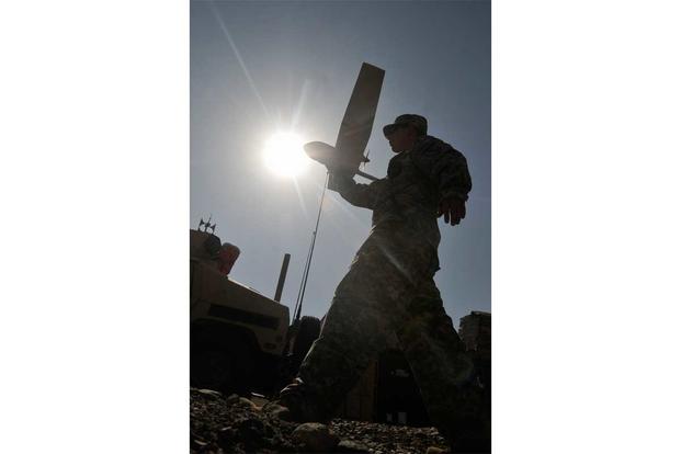 A Raven operator performs preventative maintenance checks in Afghanistan