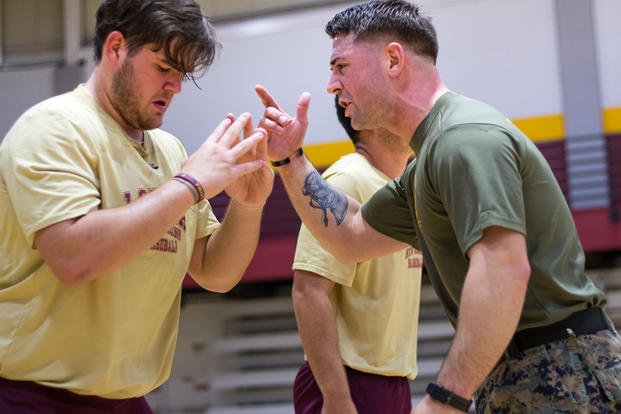 A Marine reservist motivates a member of the Loyola University baseball team. 