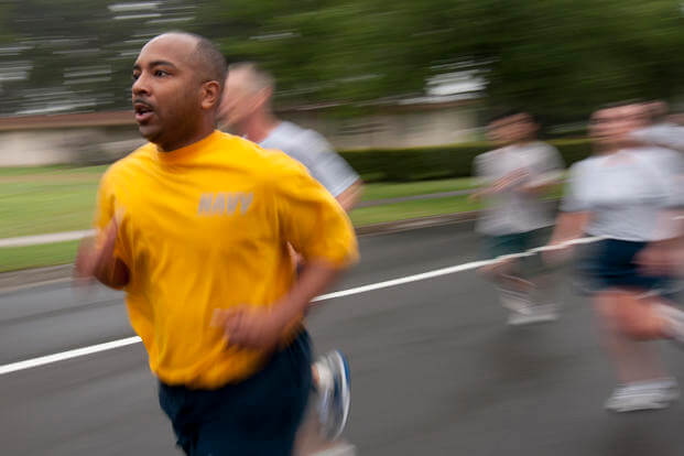 A sailor crosses the finish line during a monthly readiness run.