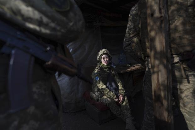 A Ukrainian soldier talks with her comrades.