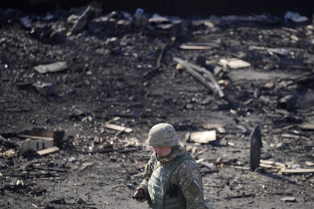 Ukrainian soldier walks through debris following a Russian airstrike in Kyiv.