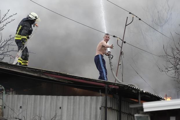 A barn burns following Russian shelling outside outside Mariupol, Ukraine.