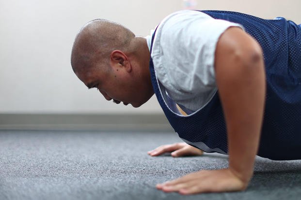 A senior airman completes one minute of traditional push-ups during a physical fitness test.