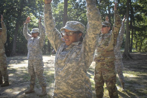 An Army reservist conducts a stretching exercise before going out onto an obstacle course.