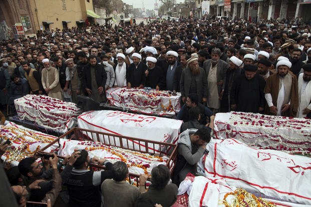 People attend the funeral prayers for the victims of a suicide bombing in Peshawar, Pakistan.