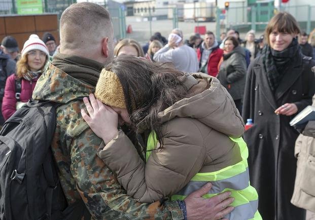 A woman hugs a Polish volunteer waiting to go and fight for Ukraine.