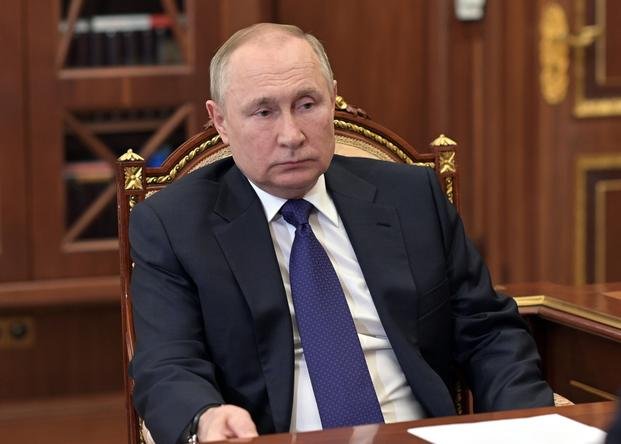 Russian President Vladimir Putin listens to St. Petersburg's governor Alexander Beglov.