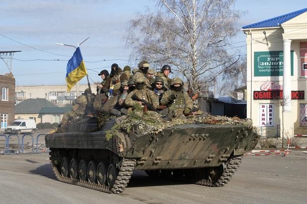 Ukrainian soldiers ride a tank through the town of Trostsyanets near Kyiv.