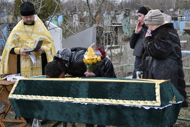 Relatives and friends stand near the coffin of Ukrainian serviceman Anatoly German during a funeral ceremony in Kramatorsk, Ukraine