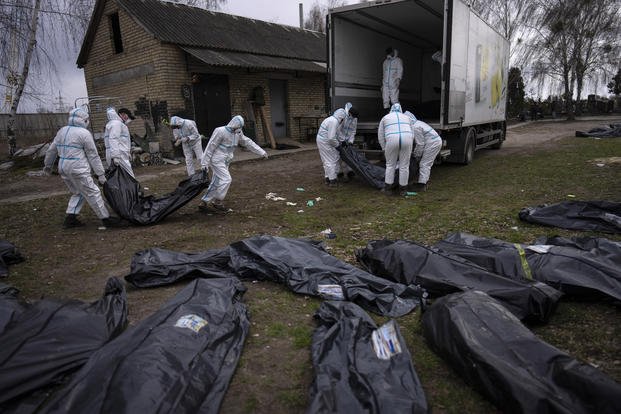 Volunteers load bodies of civilians killed in Bucha, Ukraine onto a truck.