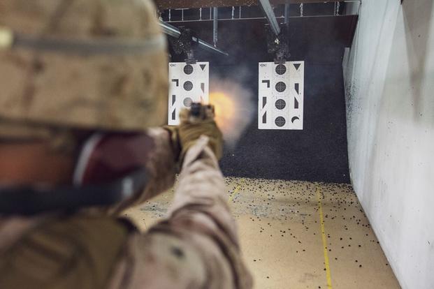 A U.S. Marine fires a M18 service pistol aboard Naval Support Activity Bahrain.