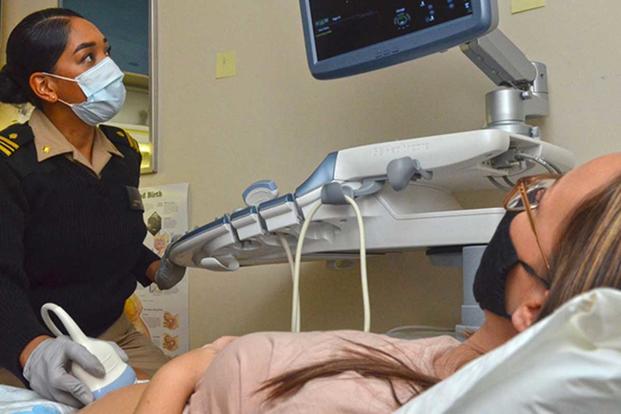 A certified nurse midwife performs an ultrasound.