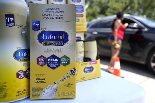 Woman helps distribute infant formula during a baby formula drive.
