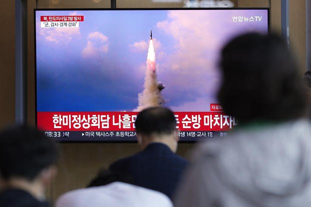 People watch a news program reporting about North Korea's missile launch.