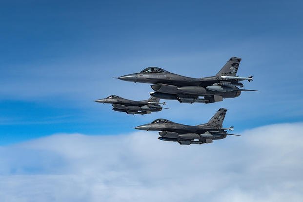 Three F-16 Fighting Falcons fly alongside a KC-135 Stratotanker.