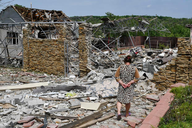 elderly woman walks next to a building damaged by an overnight missile strike in Sloviansk, Ukraine