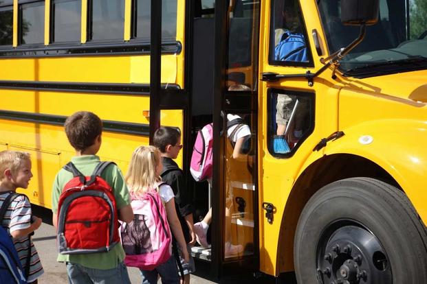 Children board a school bus at Schriever Air Force Base.