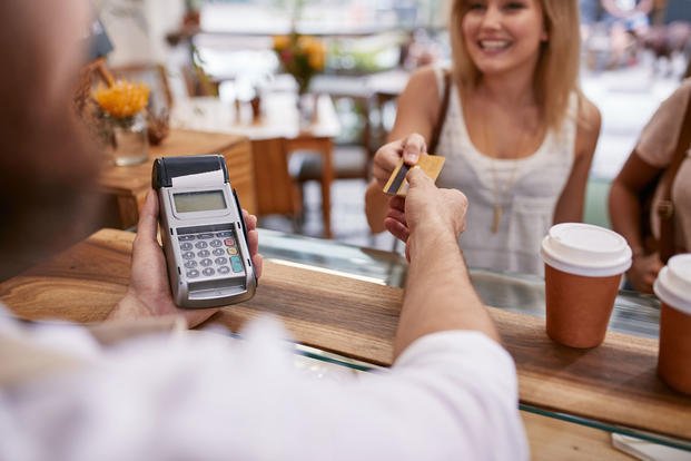woman checking out with credit card at cafe