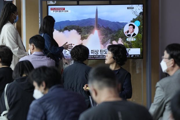 People watch a news program showing a file image of a missile launch by North Korea at the Seoul Railway Station