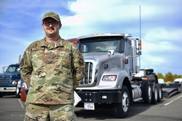 U.S. Air Force Senior Airman Garret Turner poses in front of a tractor-trailer truck at Fairchild Air Force Base, Washington.