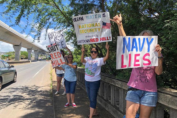 Protestors hold signs outside the gate at Joint Base Pearl Harbor-Hickam in Hawaii. 