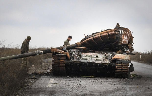 Ukrainian soldiers inspect a damaged Russian tank.