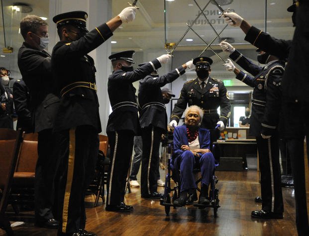 Romay Davis enters a ceremony honoring her service in World War II.