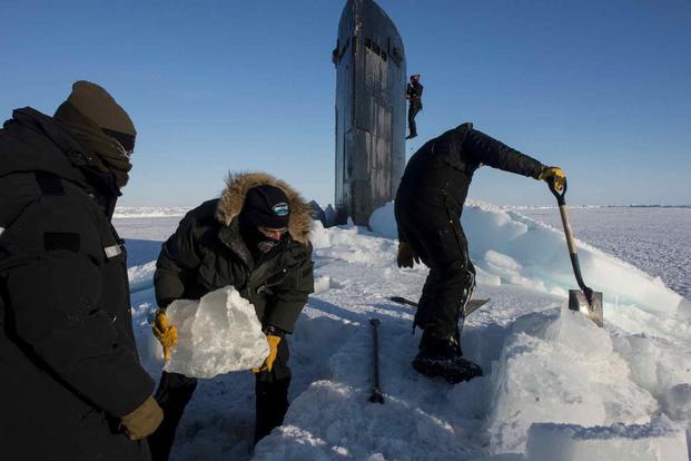 Sailors clear ice from the hatch of USS Hampton.