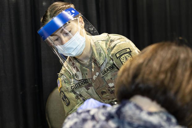 U.S. Army Sgt. Sofia Gutierrez, a combat medic at Fort Bragg, North Carolina, administers a COVID vaccine to a patient at the Community Vaccination Center at the Wisconsin Center in Milwaukee.