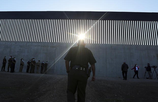 U.S. Border Patrol agent walks up to a new section of the border wall