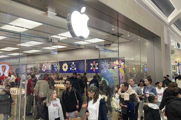File - People shop at an Apple store in the Westfield Garden State