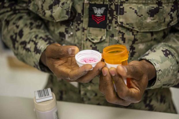 U.S. Navy pharmacy outpatient instructor checks medication orders.