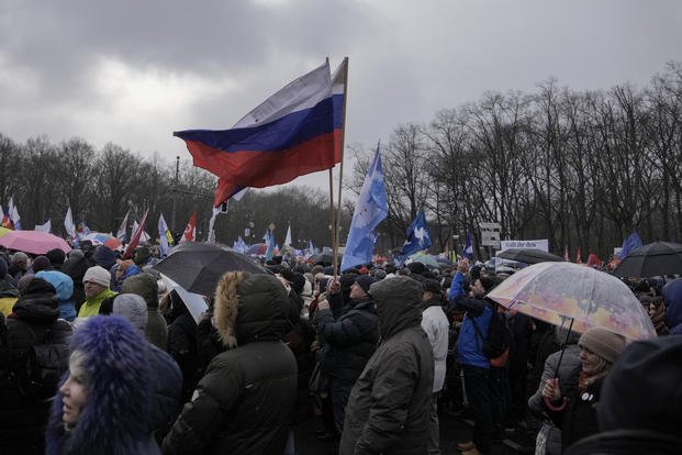 A man waves Russian flags as he attends a demonstration in Germany. 