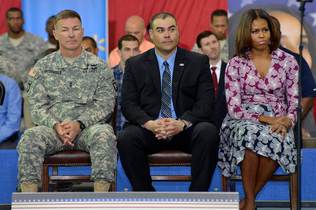 U.S. Army Maj. Gen. James McConville the commanding general of the 101st Airborne Division (Air Assault) "Screaming Eagles;" Sgt. Aaron Wanless from the 4th Brigade Combat Team; and first lady Michelle Obama sit on stage as the second lady, Jill Biden, speaks to soldiers, family members and employers during the Veterans Job Summit and Career Forum at Fort Campbell, Ky.