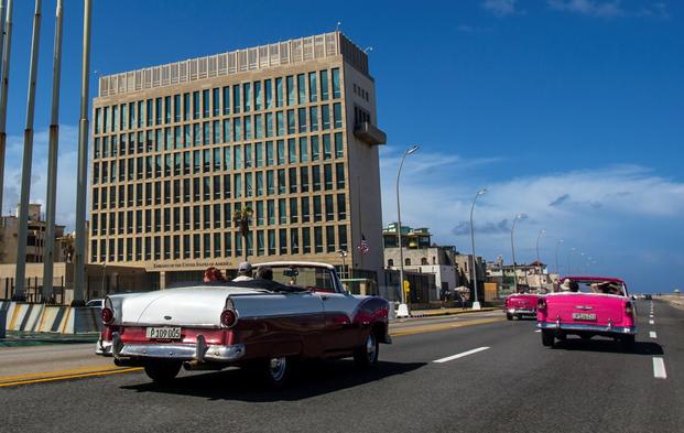 Tourists ride classic convertible cars on the Malecon beside the U.S. Embassy in Havana, Cuba.