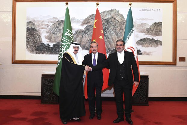 Ali Shamkhani shakes hands Musaad bin Mohammed al-Aiban.