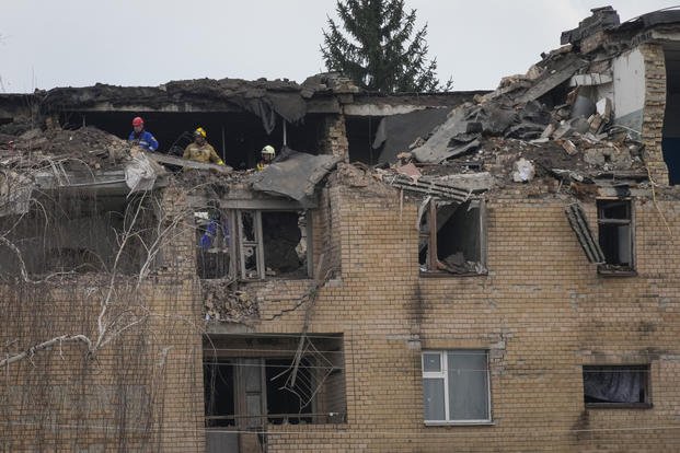 Emergency personnel work at the scene following a drone attack in the town of Rzhyshchiv