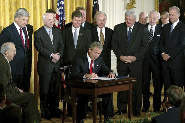 President George W. Bush signs a resolution authorizing the use of force against Iraq